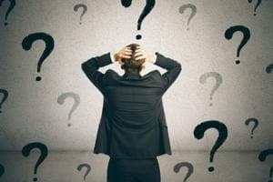 a man looking a wall with question marks.