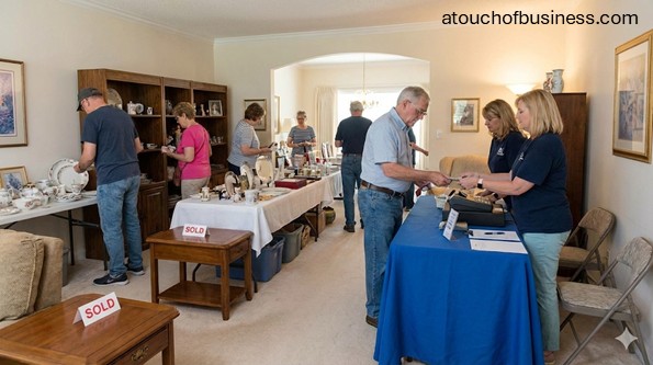 A busy estate sale with customers browsing items inside a home and a checkout area with staff.