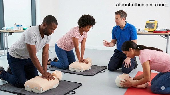 Instructor and trainees practicing CPR on mannequins during a first aid training course.