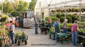 Staff and customers at a busy garden supply business with plants, a greenhouse, and a forklift in operation.