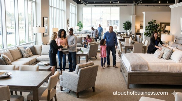 Customers browsing modern living room and bedroom displays in a well-lit retail furniture store showroom.