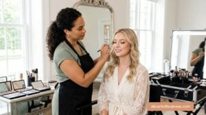 Makeup artist applying detailed bridal eyeshadow in a modern, well-lit studio environment with professional cosmetics.