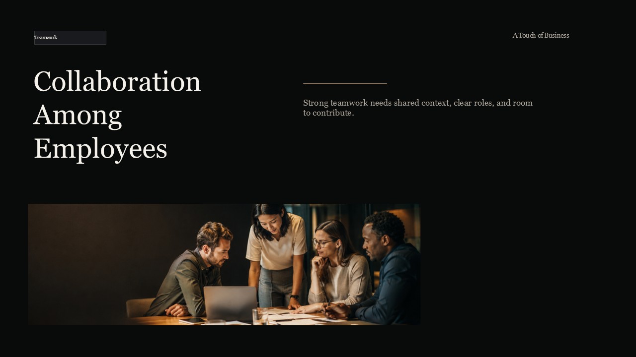 Four professionals collaborating around a wooden table in a warmly lit office meeting.
