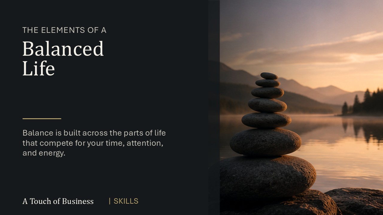 Stack of smooth balancing stones beside a calm mountain lake at sunset.