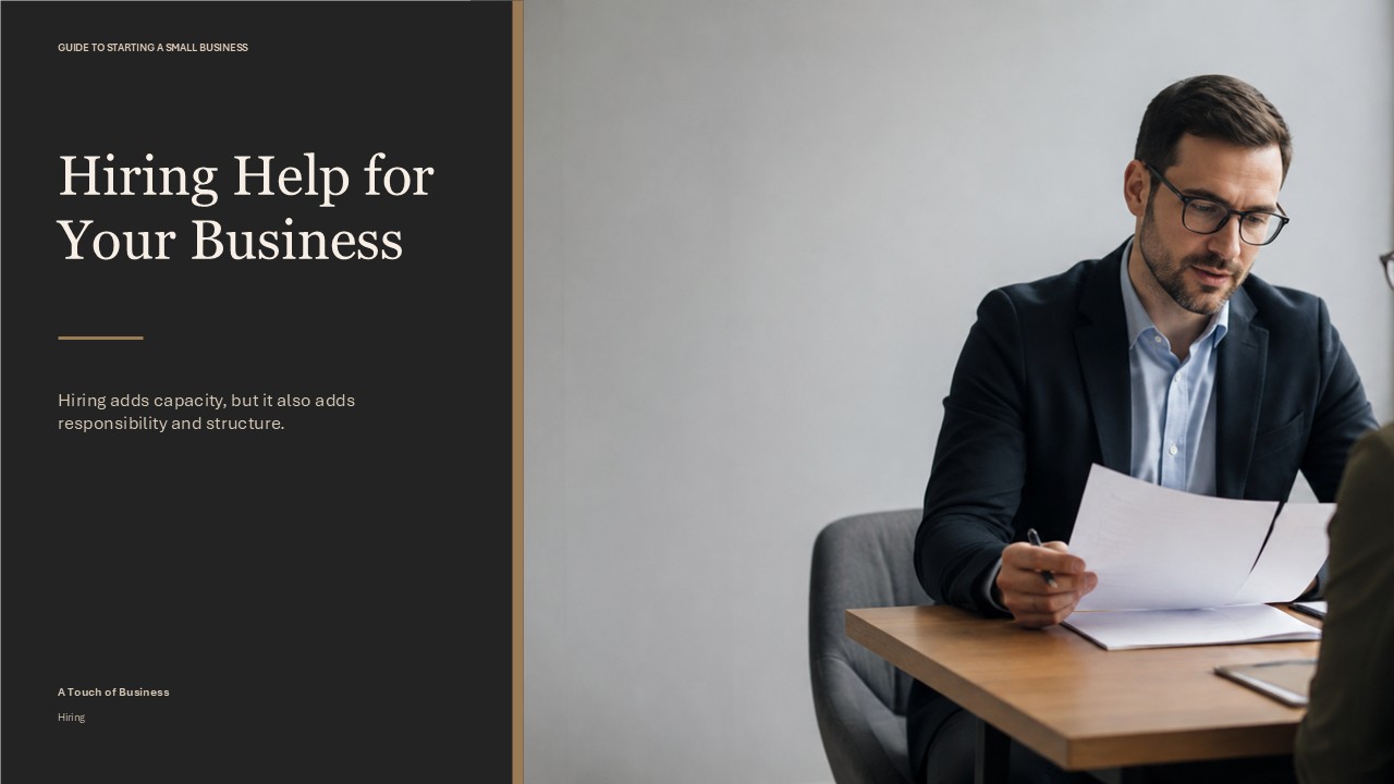 Professional meeting with documents at a small office table in soft window light.