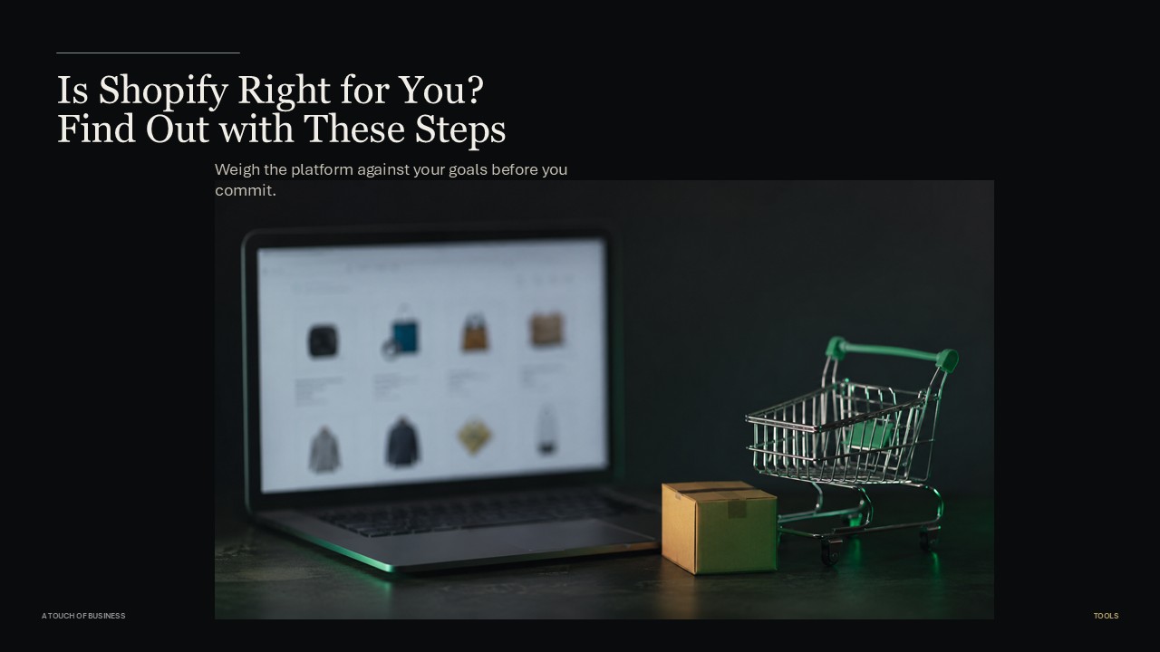 Mini shopping cart and cardboard box on a dark desk with a blurred laptop behind them.