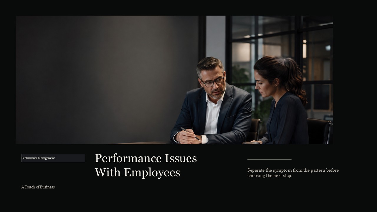 Manager reviewing performance documents with an employee at a dark conference table.