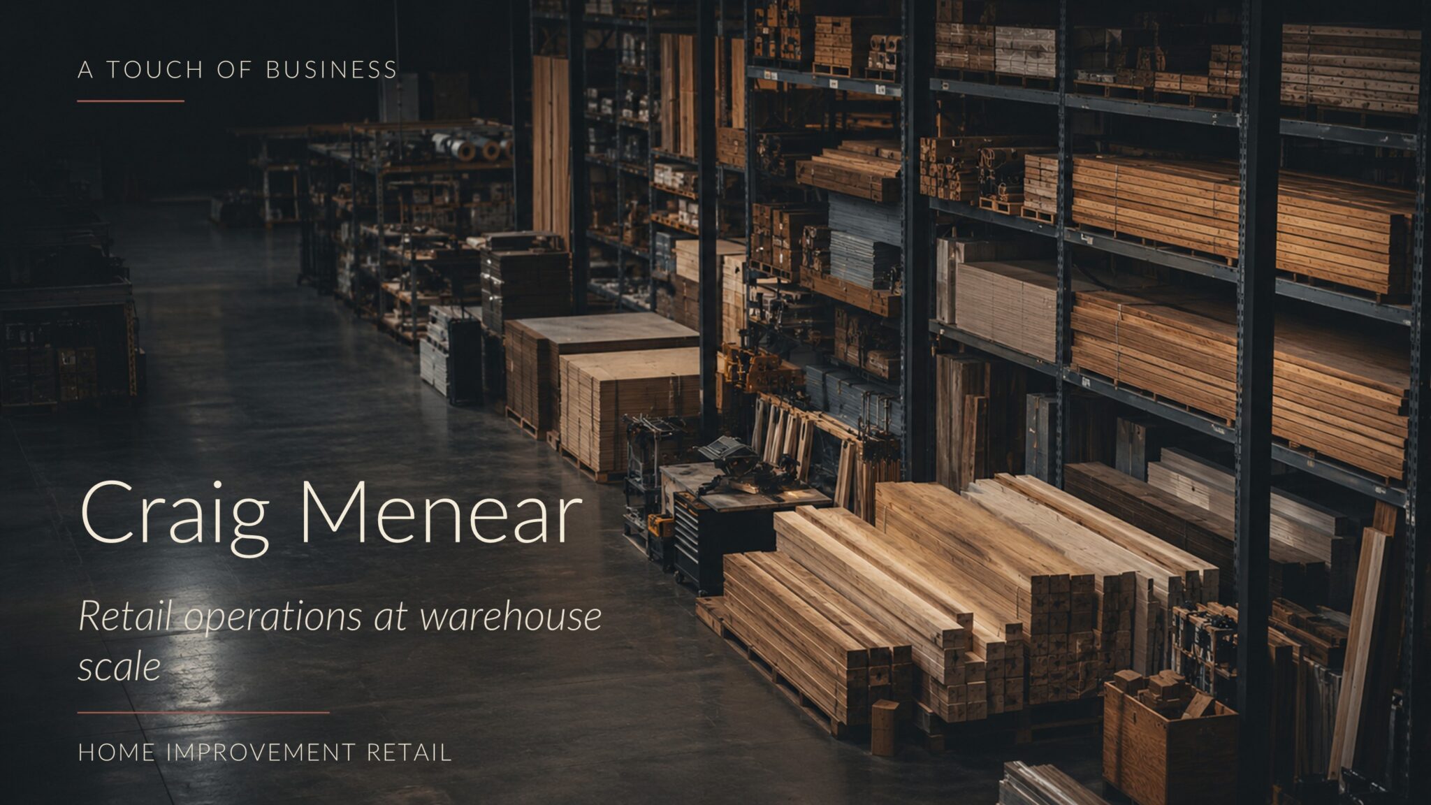 Dim warehouse-style home-improvement space with lumber, shelving, tools, and open concrete floor.