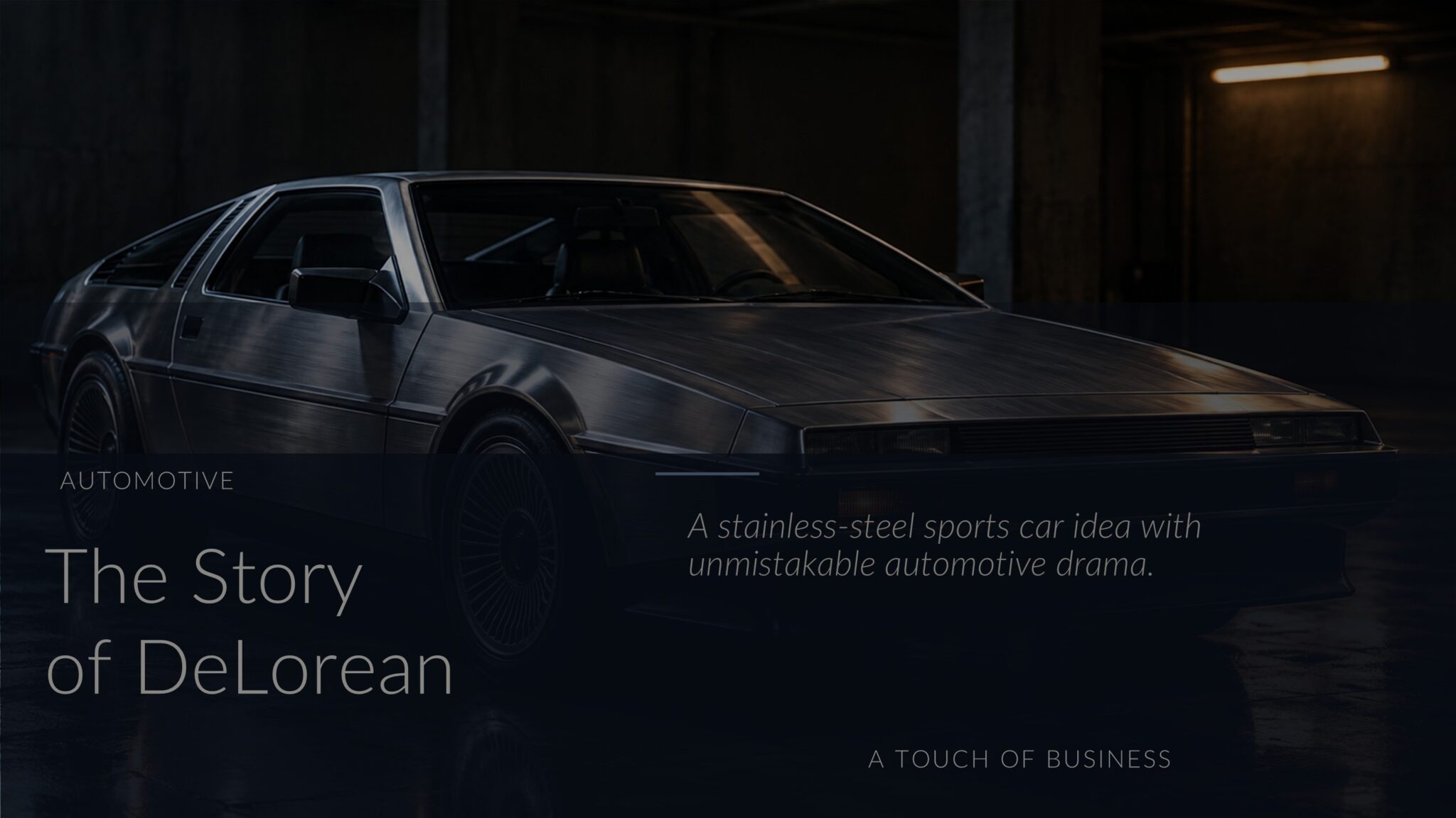 Brushed-silver wedge-shaped sports car in a dark industrial garage with wet floor reflections.